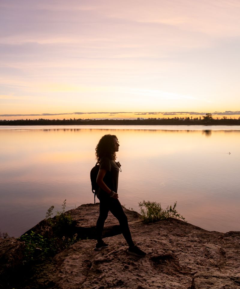 traveler-woman-walking-by-the-lake-during-sunset